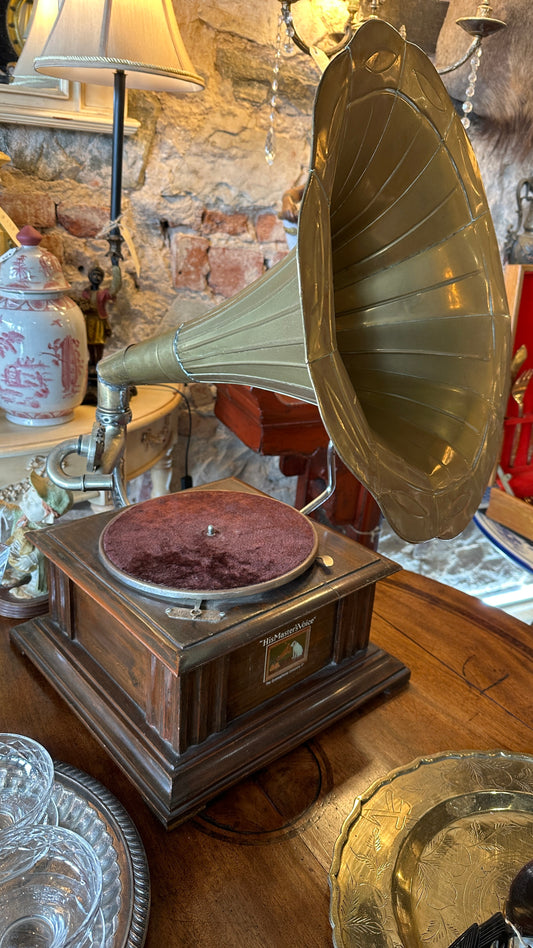Vintage Gramophone HMVS, with a wooden base, a side hand crank, and a large brass horn.