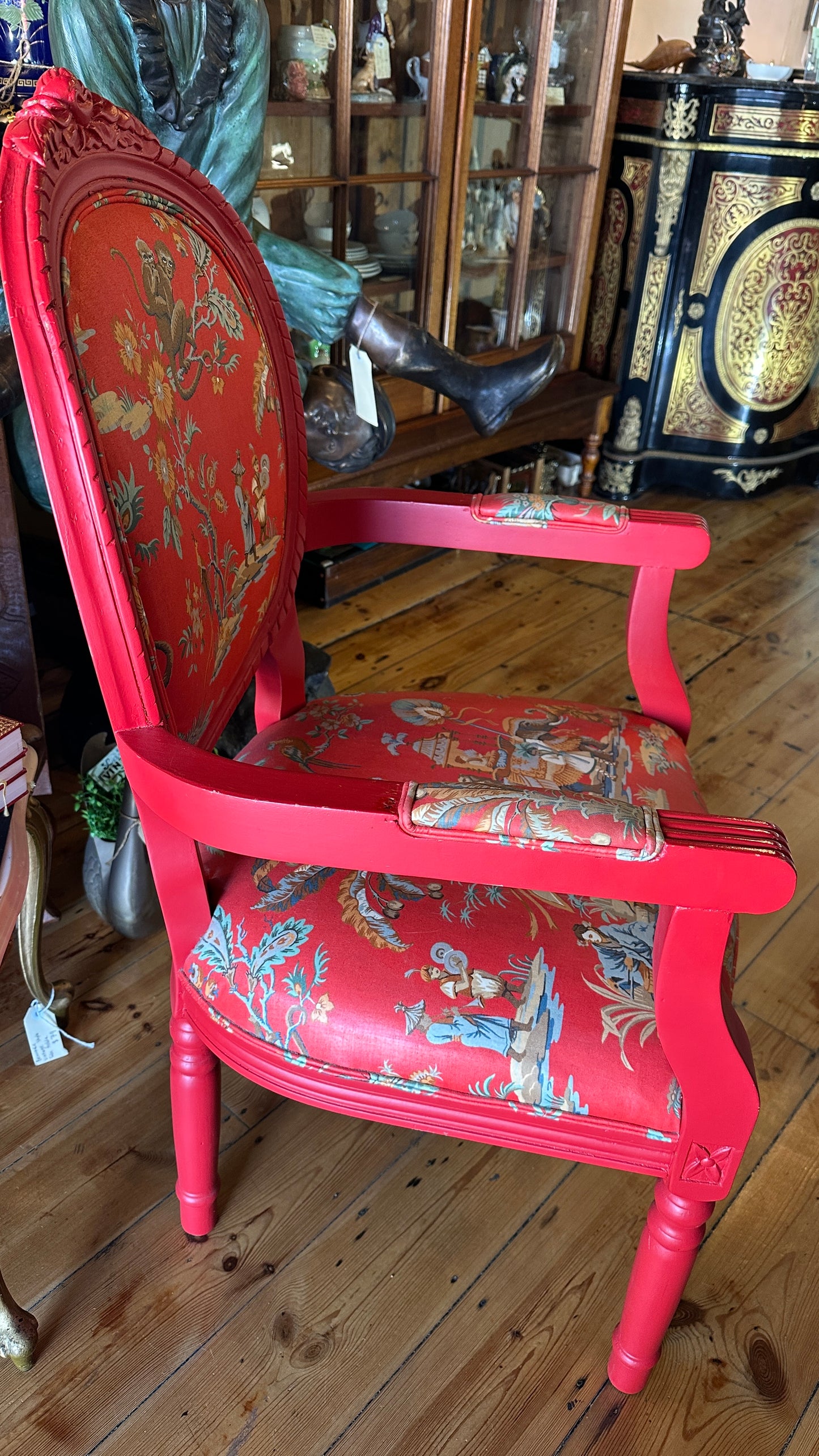 Striking Louis XVI-style armchair exquisitely upholstered in a red Chinoiserie garden scene motif