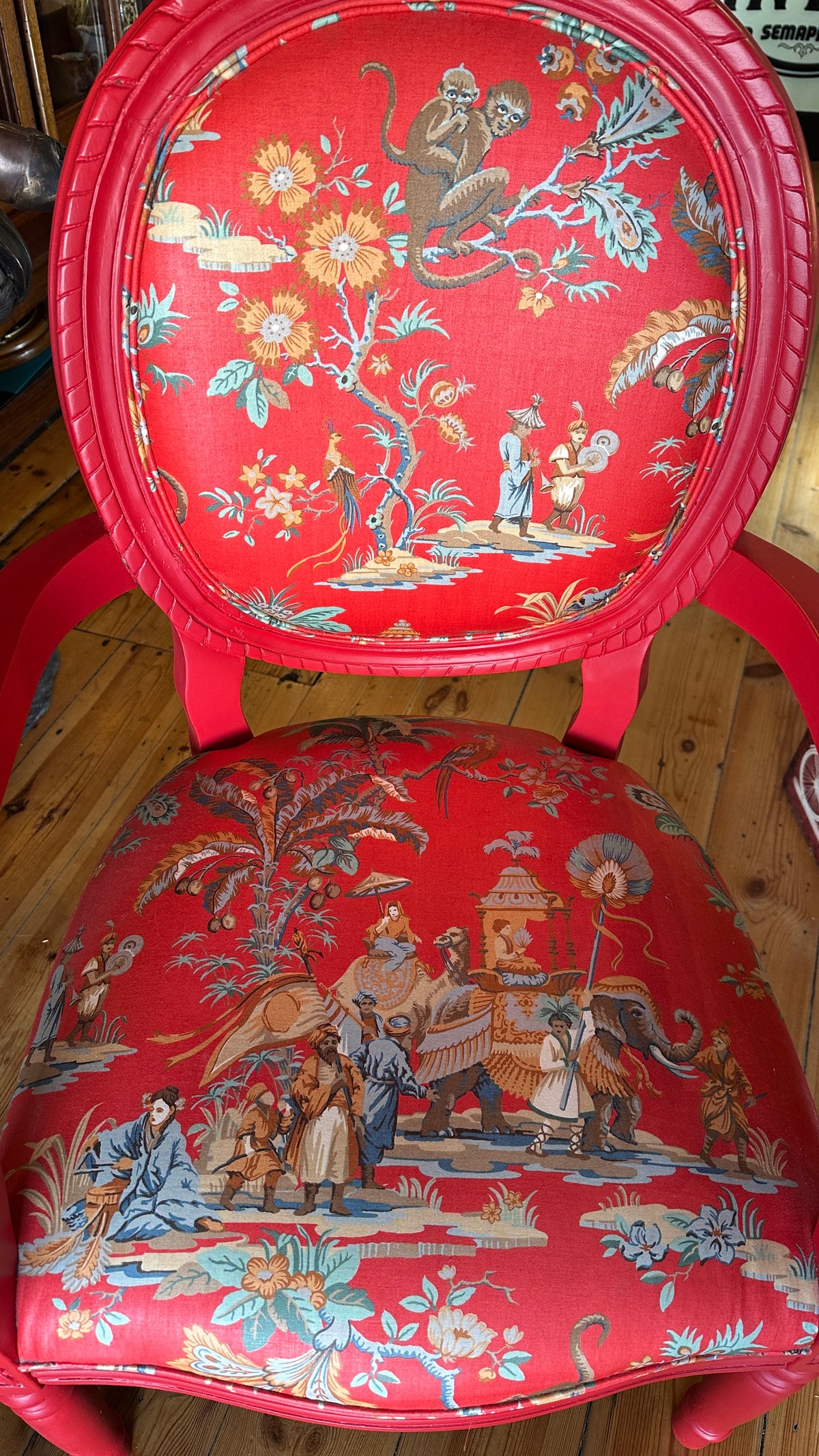Striking Louis XVI-style armchair exquisitely upholstered in a red Chinoiserie garden scene motif