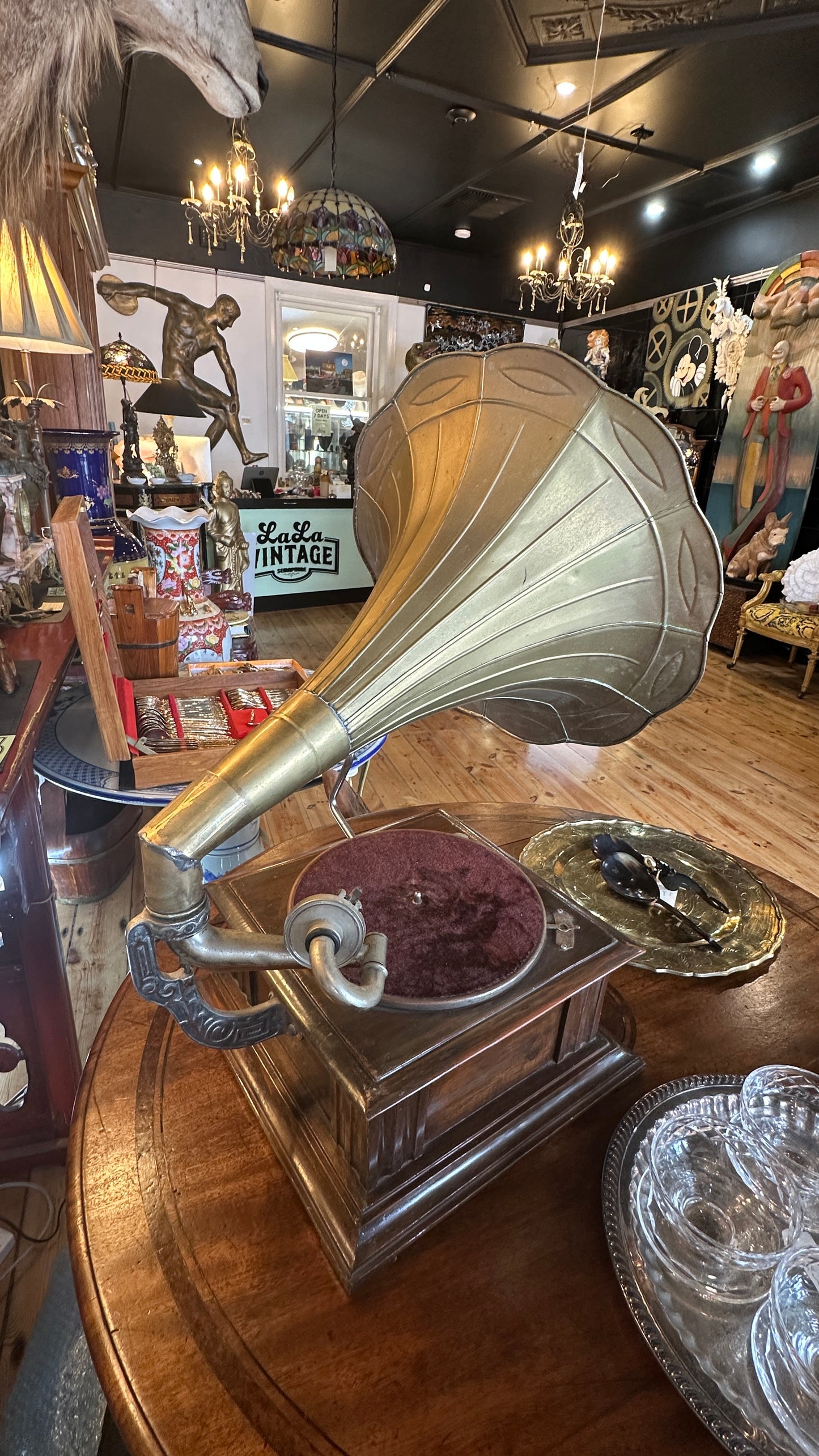 Vintage Gramophone HMVS, with a wooden base, a side hand crank, and a large brass horn.