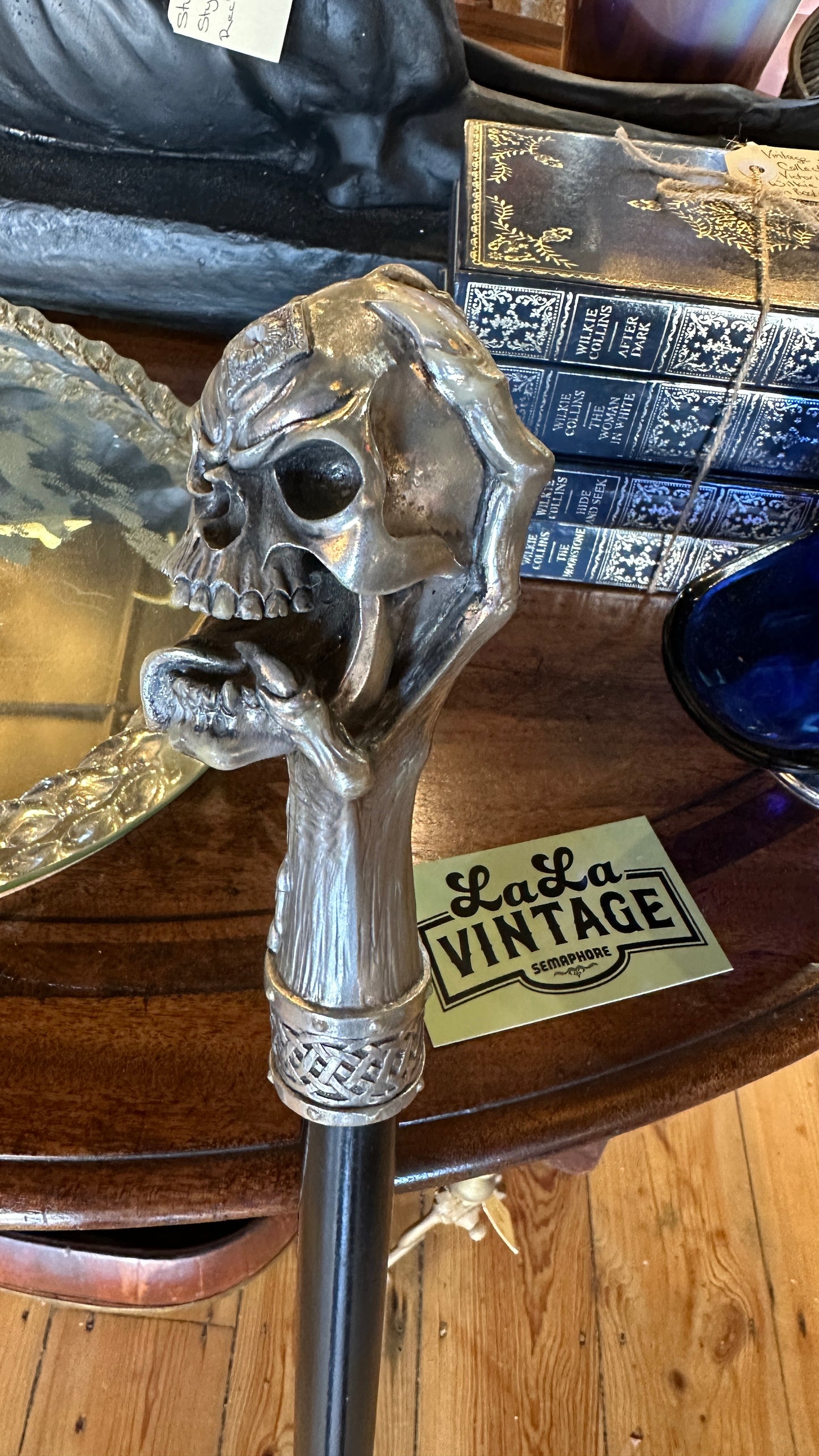 Walking cane/ stick featuring a gothic style silver-colored skull handle mounted on a black shaft