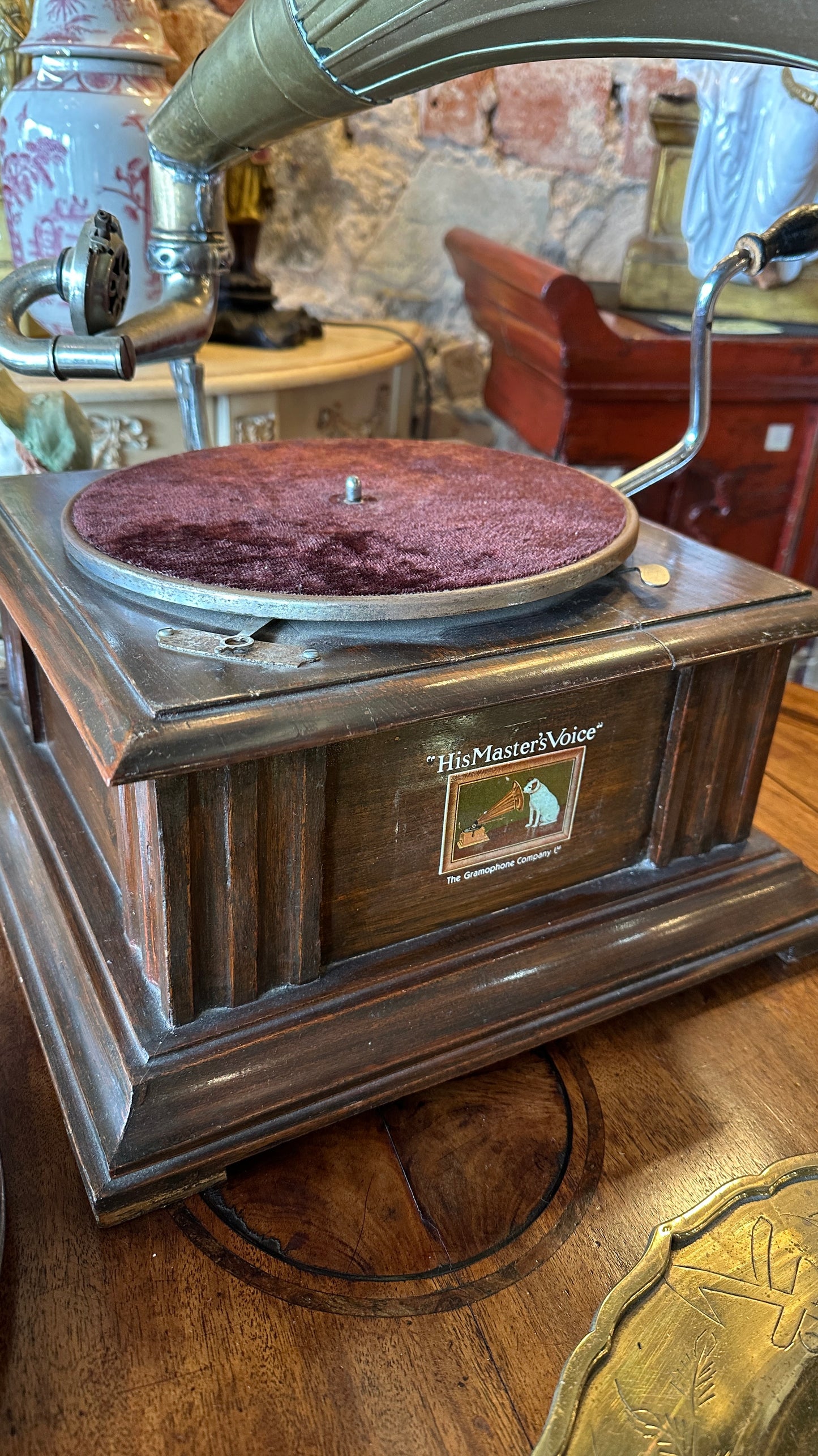 Vintage Gramophone HMVS, with a wooden base, a side hand crank, and a large brass horn.