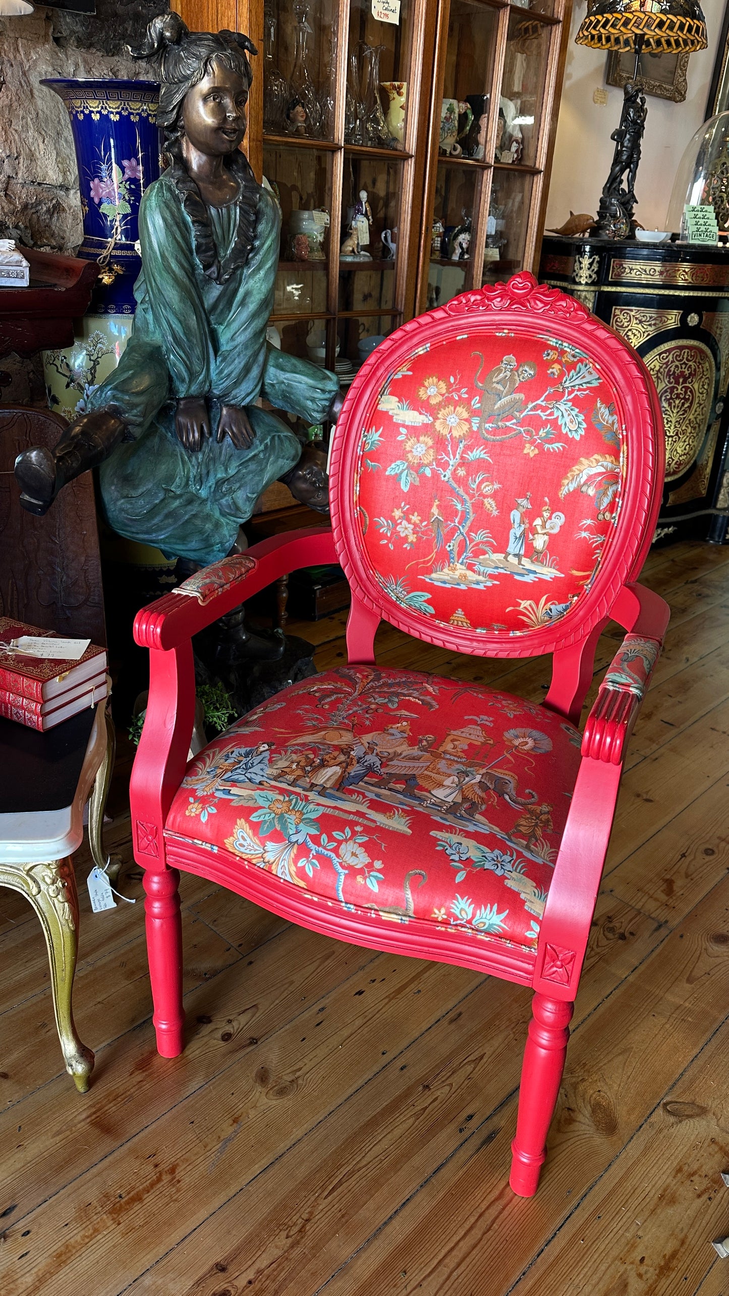 Striking Louis XVI-style armchair exquisitely upholstered in a red Chinoiserie garden scene motif