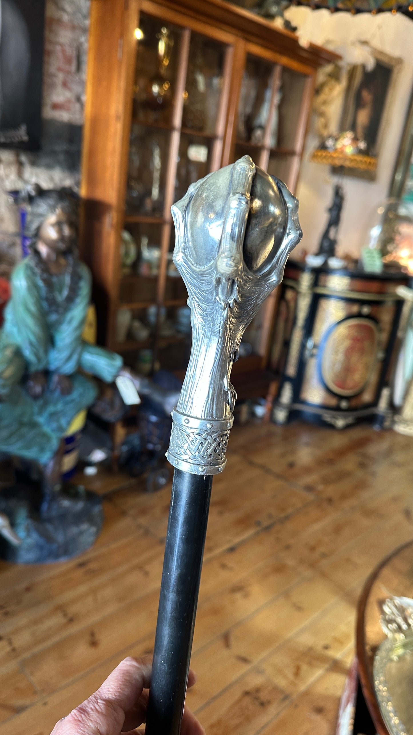Walking cane/ stick featuring a gothic style silver-colored skull handle mounted on a black shaft