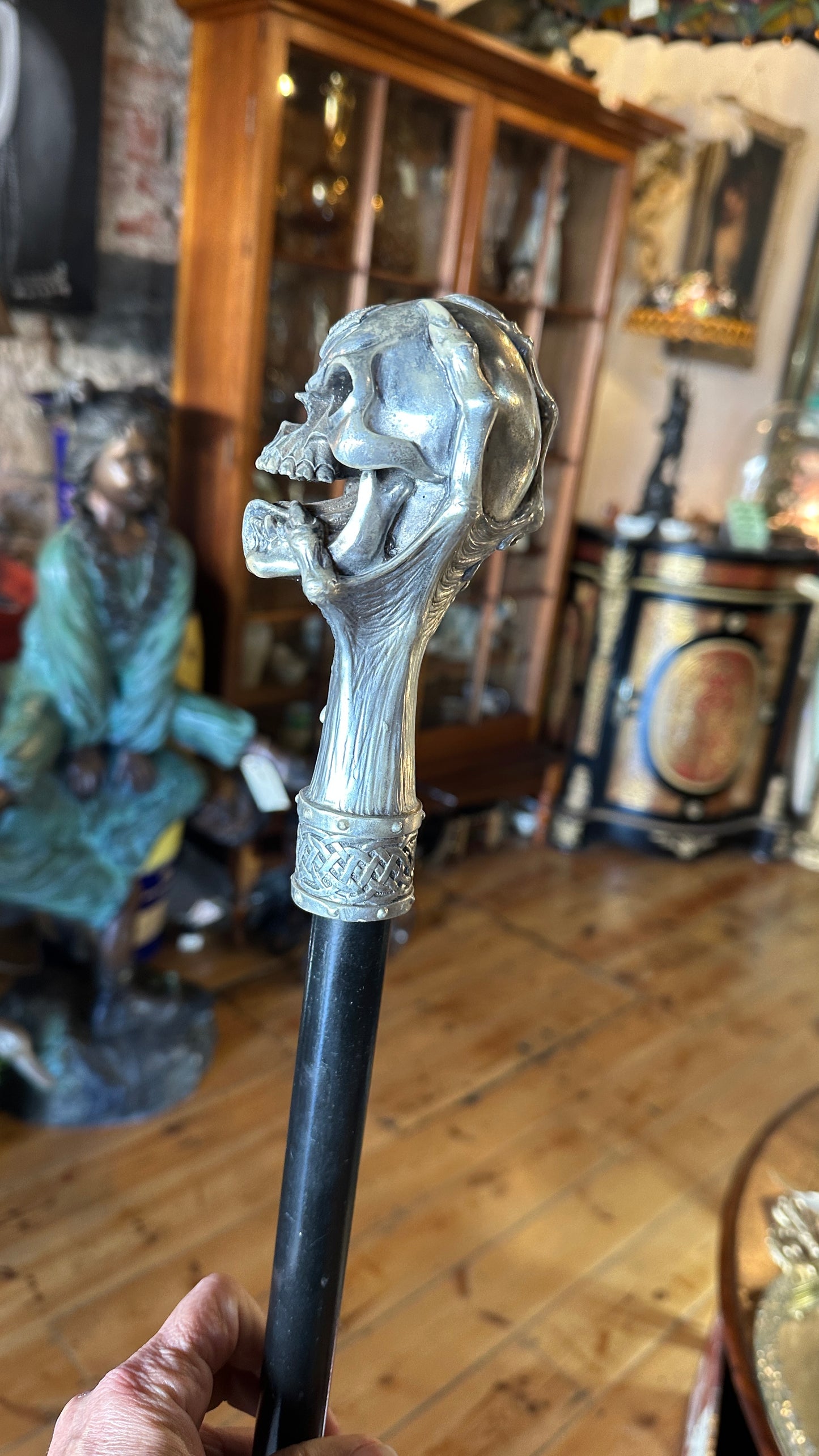 Walking cane/ stick featuring a gothic style silver-colored skull handle mounted on a black shaft