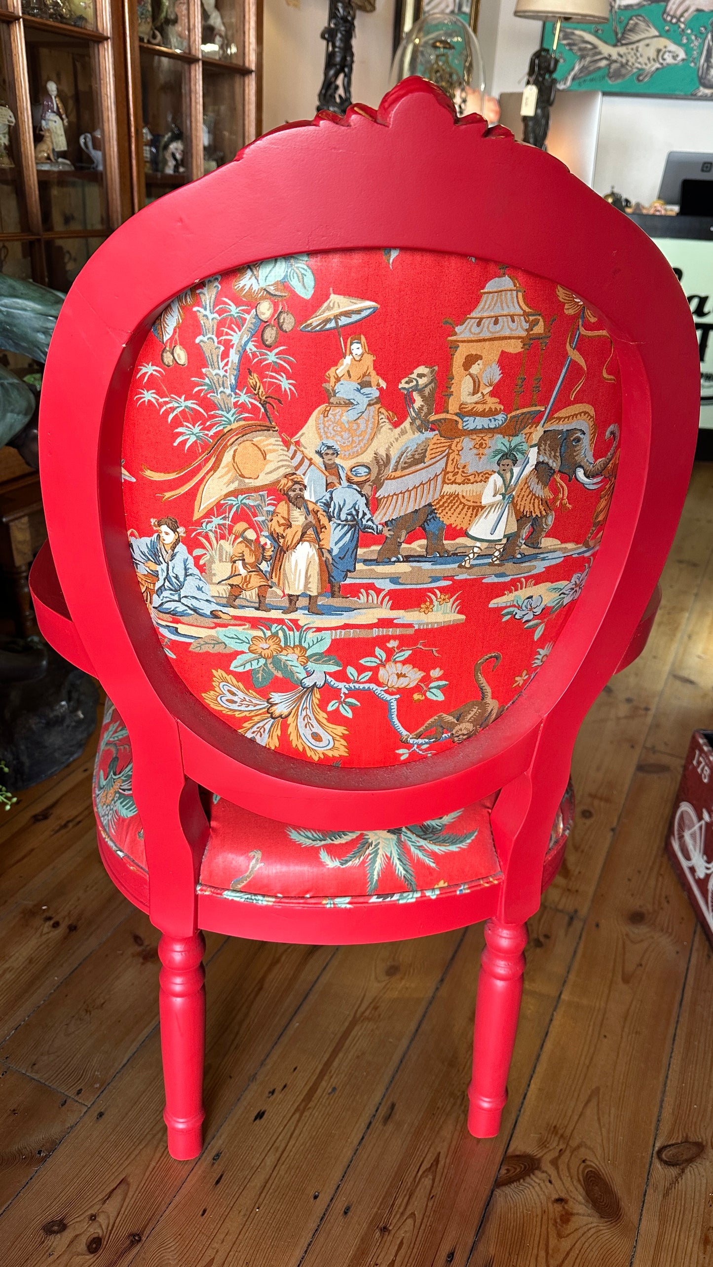 Striking Louis XVI-style armchair exquisitely upholstered in a red Chinoiserie garden scene motif