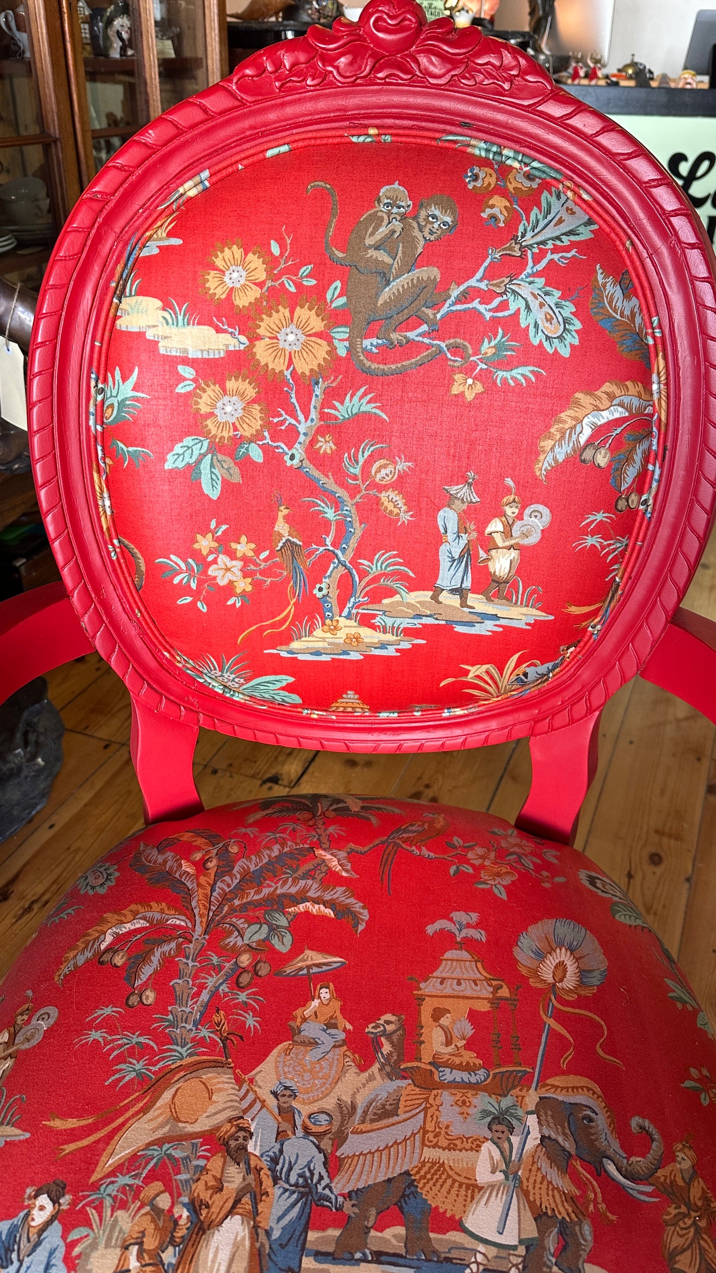 Striking Louis XVI-style armchair exquisitely upholstered in a red Chinoiserie garden scene motif
