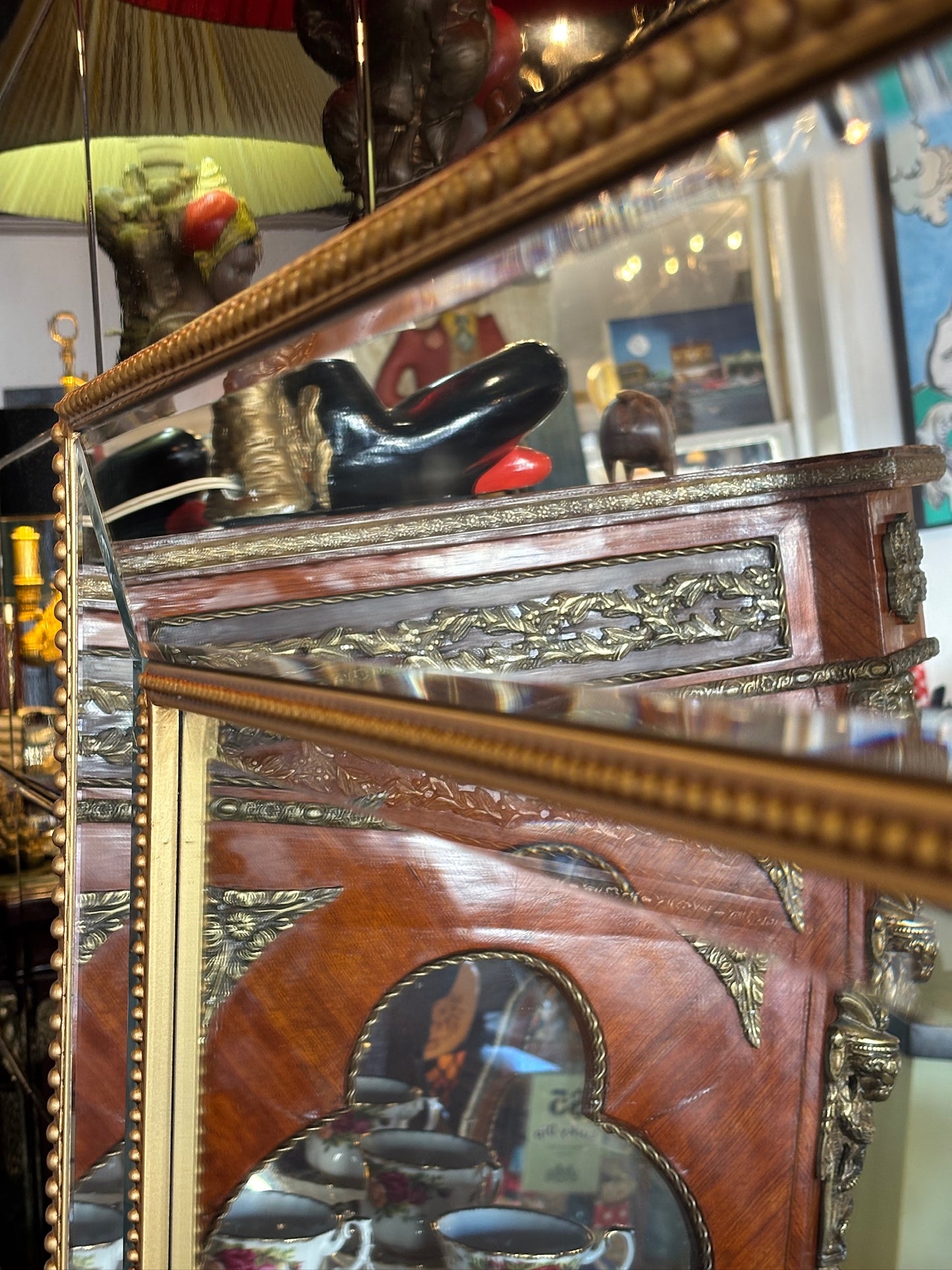 Large mirror features a classic bevel-edged glass pane set within a slender gold-beaded wooden frame