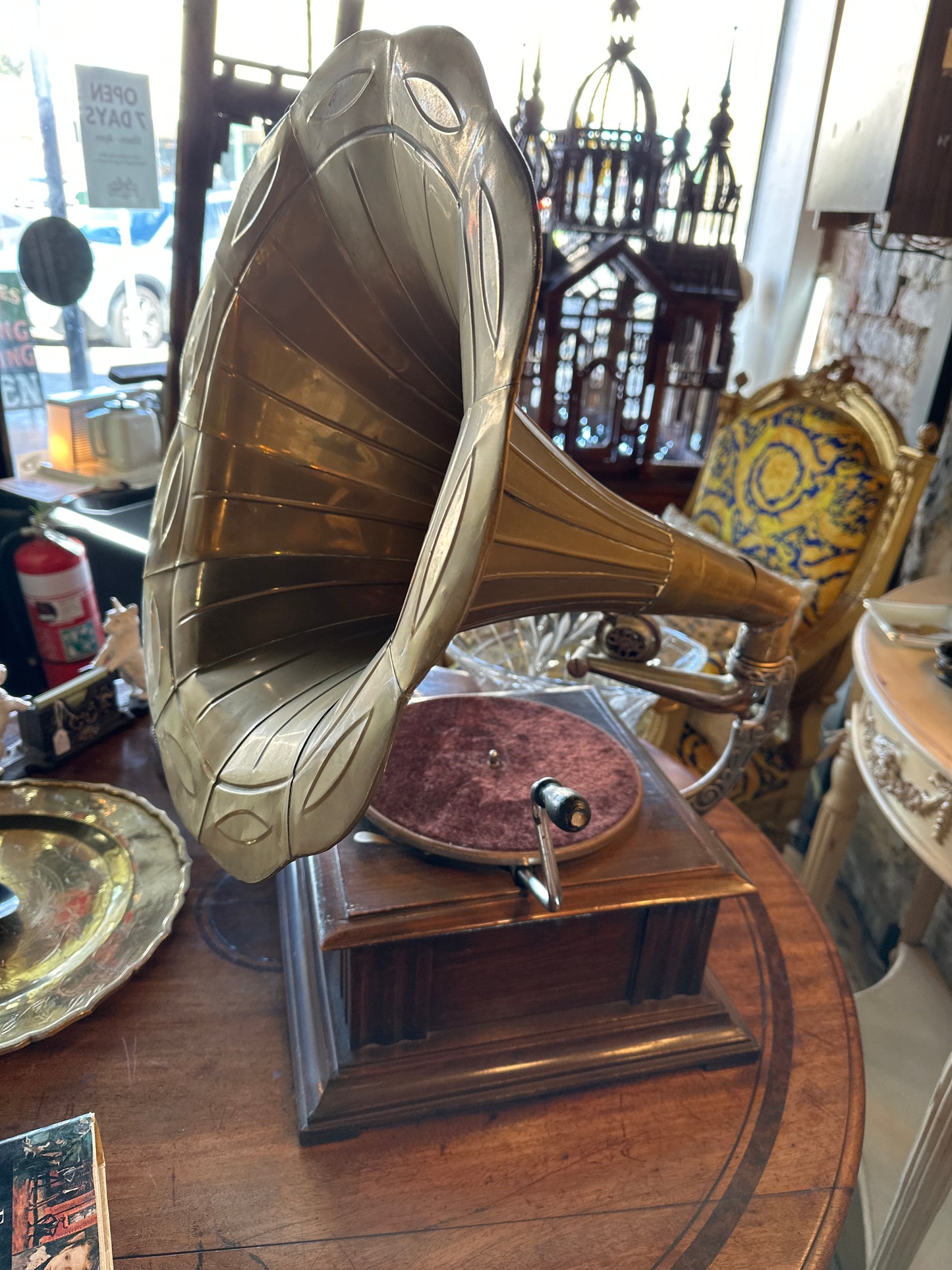 Vintage Gramophone HMVS, with a wooden base, a side hand crank, and a large brass horn.